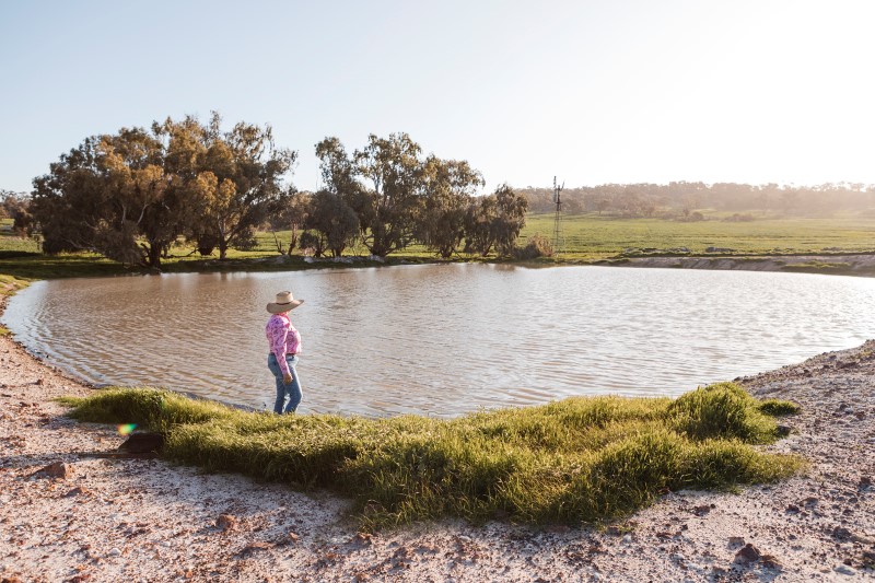 Woman walking at dam on farm property